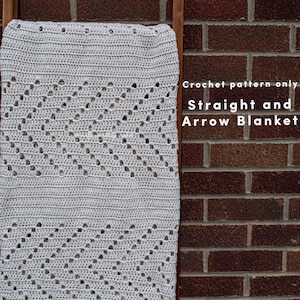 Pode incluir: Um padrão de crochê para um cobertor branco com um design reto e uma flecha. O padrão é chamado de "Straight and Arrow Blanket".