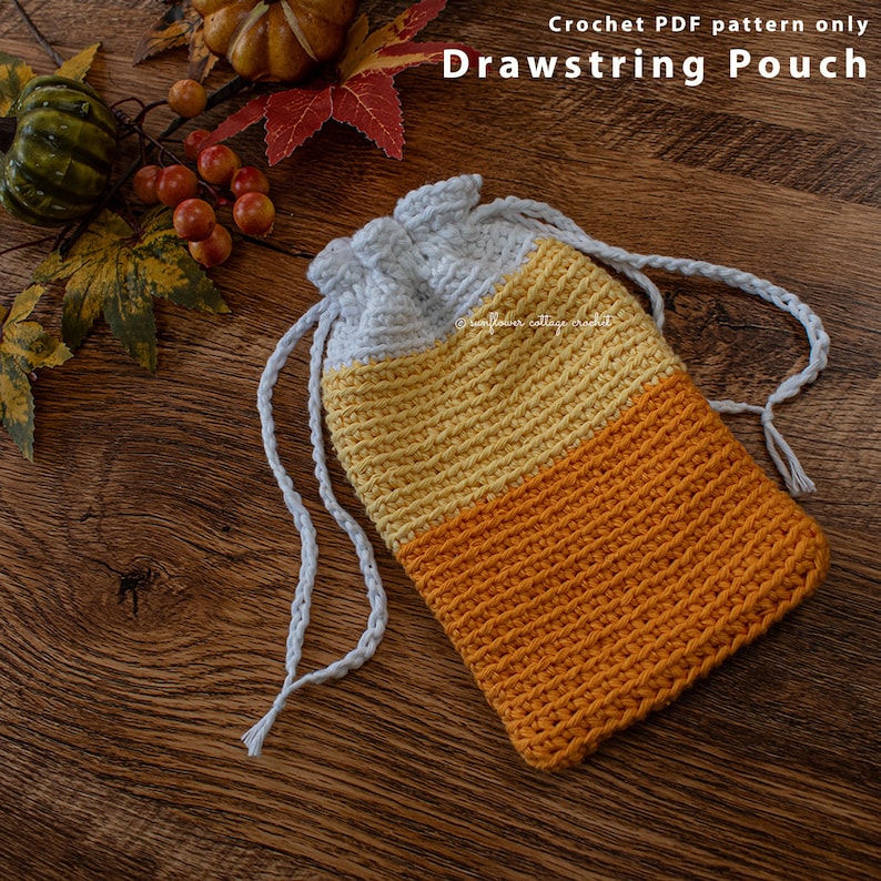 May include: A crocheted drawstring pouch with white, yellow, and orange stripes. The pouch is lying on a wooden surface with fall foliage around it.  Crochet PDF pattern only Drawstring Pouch.