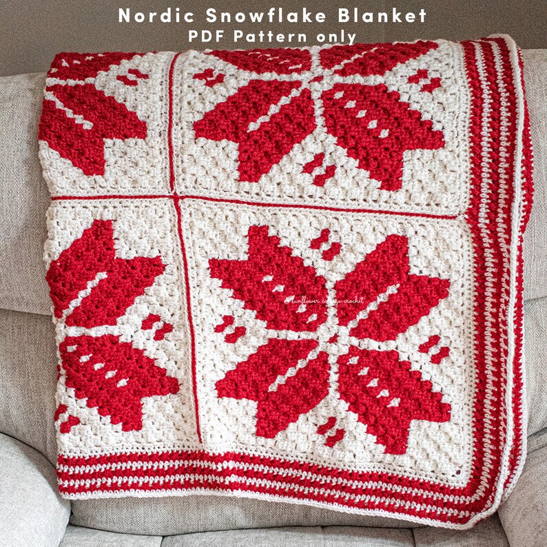 Puede incluir: Una manta de crochet blanca y roja con un patr&oacute;n de copo de nieve. La manta est&aacute; doblada y sentada en un sof&aacute;. El texto "Nordic Snowflake Blanket PDF Pattern only" est&aacute; en la parte superior de la imagen.