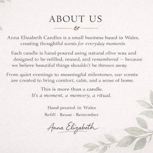 May include: A cream-colored card with the text "ABOUT US" and information about Anna Elizabeth Candles. The text describes the company's values, hand-poured candles, and commitment to sustainability. Decorative green leaves frame the text.