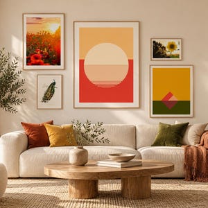 Può includere: Una parete galleria con cinque stampe artistiche incorniciate sopra un divano color crema. Le stampe includono un tramonto su un campo di papaveri, un grande grafico solare geometrico, un'illustrazione di un pavone, un girasole e un paesaggio montano.