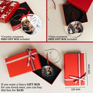 May include: A round ceramic ornament featuring a couple and a map, and a round glass ornament displaying a family photo, both presented in red gift boxes. The glass ornament box measures 200 mm by 120 mm, with red ribbons and silver trim.