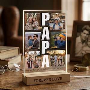 May include: A lighted photo display with the word "PAPA" in large white letters. The display includes family photos and the phrases "best" and "ever". The wooden base reads "FOREVER LOVE".