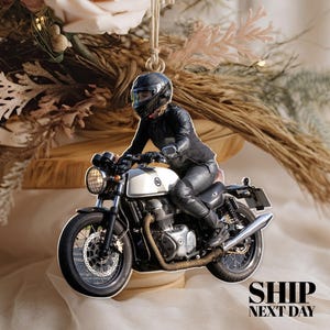 May include: A white motorcycle with a black leather-clad rider. The motorcycle has a round headlight and a black seat. The rider is wearing a black helmet and gloves. The motorcycle is on a white surface with a floral background.