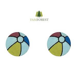 May include: Two round, colorful beach ball designs. Each ball features segments of red, blue, yellow, and light blue, separated by black lines. The design is reminiscent of a classic beach ball.