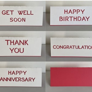 Może przedstawiać: Sześć białych kartek z czerwonym tekstem. Kartki zawierają napisy: "Get Well Soon", "Happy Birthday", "Thank You", "Congratulations", "Happy Anniversary" oraz kartka pusta.