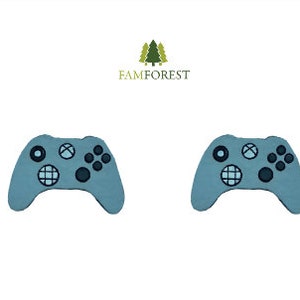May include: Two blue plastic video game controllers with black buttons and a black and white design on the face of the controller.