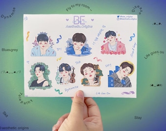May include: A set of 6 stickers featuring illustrations of a young man with different colored backgrounds and text. The text includes the words "Fly to my room", "BE", "Live On", "Aesthetic. Origins", "Bluesgrey", "Skit", "Stay", "Dynamite", "Life goes on", and "Blue & Grey".