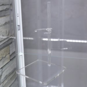 Puede incluir: Un soporte de acr&iacute;lico transparente con un solo brazo ajustable para exhibir figuras u otros objetos peque&ntilde;os.
