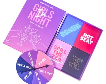 Puede incluir: Una caja morada con el texto "Girls Night The Card Game" y un dibujo de dos manos sosteniendo copas de champán. La caja contiene cuatro cajas más pequeñas con el texto "Bonus", "Hot Seat", "Spill the Tea" y "This or That". También hay un spinner morado y rosa con el texto "Trivia", "Take a Shot", "This or That", "Hot Seat" y "Spill the Tea".