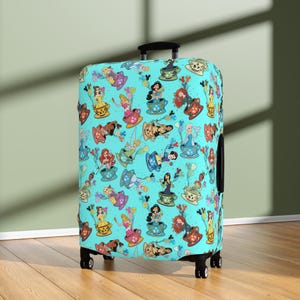 May include: A teal suitcase cover with a repeating pattern of cartoon princesses in teacups and balloons. The princesses are in various teacups of different colours. The suitcase has a black handle and wheels.