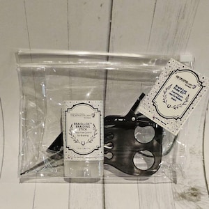 May include: A clear plastic bag containing a braid-lox braiding stick, a black hair clip, and a card that reads "Braid-Lox Show Kit™ Everything you need for flawless braids".