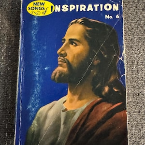 May include: Vintage book cover with a portrait of a man with long hair and a beard, set against a blue background. The cover reads "NEW SONGS of INSPIRATION" in yellow and white text, with "No. 6" in the upper right corner. The book has visible wear.