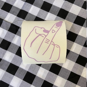 May include: A pink vinyl sticker of a middle finger with a small heart on the fingernail.