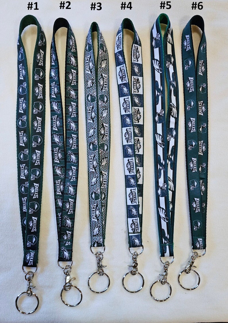 Puede incluir: Seis llaveros diferentes con cord&oacute;n de los Philadelphia Eagles, con un esquema de color verde y blanco. Cada cord&oacute;n presenta un dise&ntilde;o diferente con el logotipo de los Eagles y la palabra "Eagles".