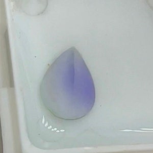 May include: A teardrop-shaped, light purple gemstone with a white centre.