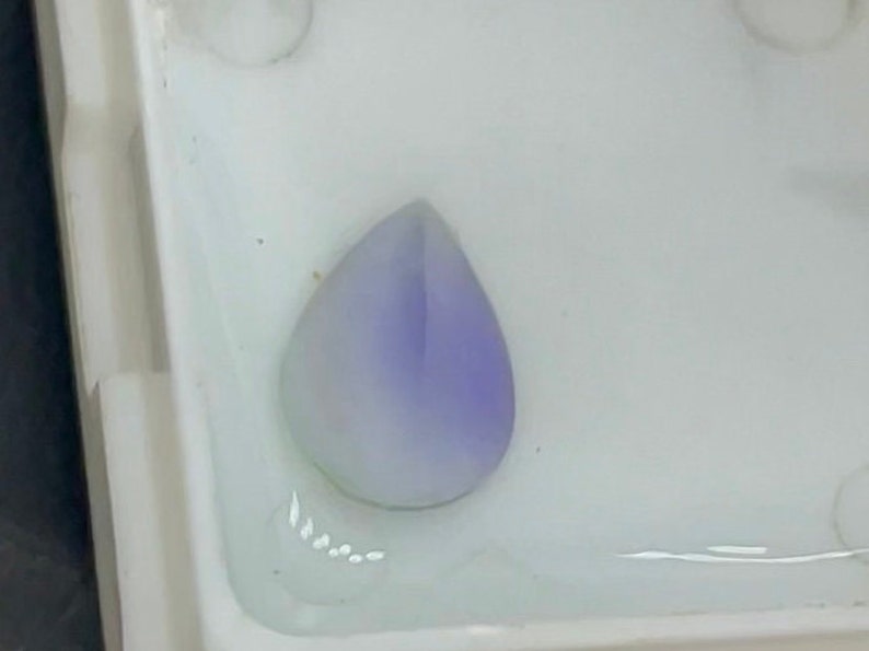 May include: A teardrop-shaped, light purple gemstone with a white centre.