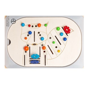 以下が含まれることがあります： アライグマのデザインが施された木製のおもちゃ。アライグマの体には、青、オレンジ、赤、黄色のボールが付いています。おもちゃには、青とターコイズ色の花の形と、赤い花の形も付いています。