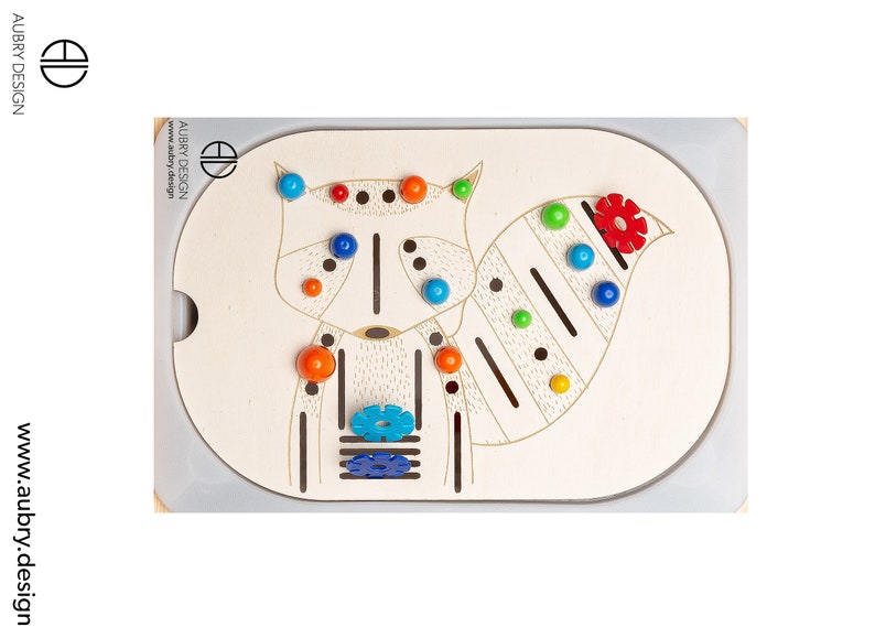 以下が含まれることがあります： アライグマのデザインが施された木製のおもちゃ。アライグマの体には、青、オレンジ、赤、黄色のボールが付いています。おもちゃには、青とターコイズ色の花の形と、赤い花の形も付いています。