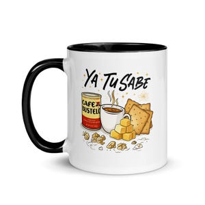 Op de afbeelding: Witte keramische mok met een zwarte handgreep en rand, met een kleurrijke illustratie van een koffiekopje, een blikje Cafe Bustelo, crackers en suikerklontjes. De tekst "Ya Tu Sabe" staat op de mok.
