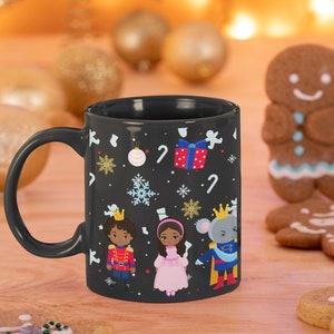 May include: Black ceramic mug with a Christmas Nutcracker theme. The mug features a Nutcracker, a ballerina, and a mouse king, all in colorful costumes. The background is black with snowflakes, candy canes, and Christmas ornaments.