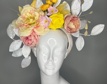 Tocado floral Golden Garden Bloom en amarillo y rosa pálido, estilo Derby, con hojas iridiscentes.