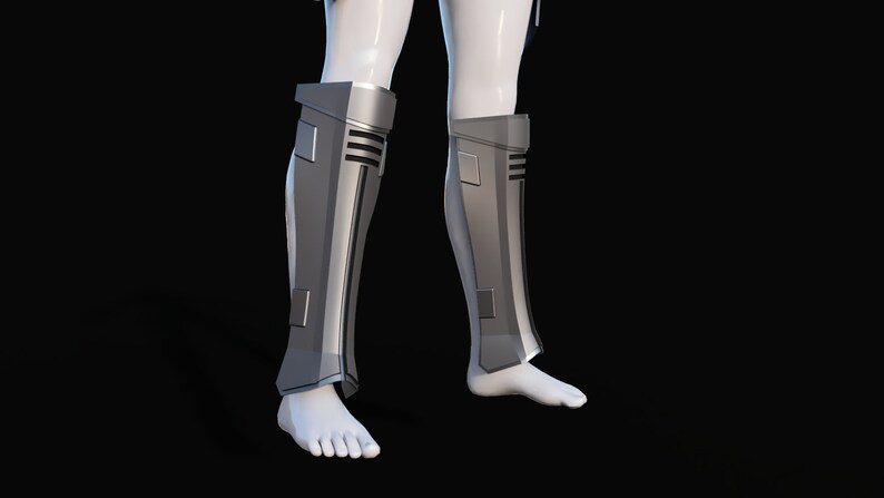 May include: A pair of silver-colored shin guards with a textured design. The guards are worn on a person's legs.