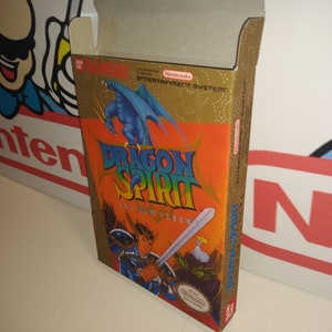 May include: A vintage Nintendo Entertainment System game cartridge box for Dragon Spirit: The New Legend. The box is gold with a blue dragon and a knight with a sword. The text "Dragon Spirit: The New Legend" is in red and white.
