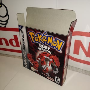 Könnte beinhalten: Eine rote und schwarze Game Boy Advance-Spielekartuschenbox für Pokemon Rubin Version. Die Box zeigt auf der Vorderseite eine rote, schwarze und weiße Illustration eines Pokemon. Der Text "Pokemon Rubin Version" ist in Weiß auf schwarzem Hintergrund gedruckt. Die USK-Bewertung "0" ist in der unteren rechten Ecke gedruckt.