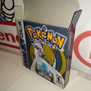 Op de afbeelding: Een blauwe en zilveren Game Boy Color-spelcartridge doos voor Pokemon Silver Version. De doos heeft een wit Pokemon met blauwe accenten en de tekst "Gotta catch 'em all!" De PEGI-classificatie is "3".
