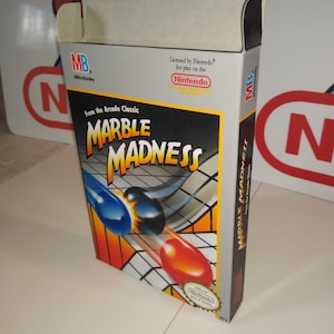 May include: A box for the Nintendo Entertainment System game Marble Madness. The box is white with red, blue, and black accents. The game is based on the arcade classic. The box features the game's title, a picture of the game's marbles, and the Nintendo Entertainment System logo.