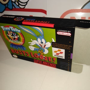 Könnte beinhalten: Eine Super Nintendo-Spielkassette für Tiny Toon Adventures: Buster Busts Loose! Die Schachtel ist schwarz mit einem grünen, blauen und gelben Bild von Buster Bunny auf der Vorderseite. Der Text "Licensed by Nintendo" befindet sich auf der rechten Seite der Schachtel. Der Text "KONAMI" befindet sich auf der rechten unteren Seite der Schachtel.