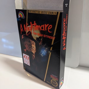 May include: A black and gold Nintendo Entertainment System game cartridge box with a red and white image of Freddy Krueger from the movie "A Nightmare on Elm Street". The box has the text "A Nightmare on Elm Street" on the front and back.