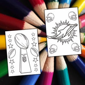 May include: Two white colouring pages with football-themed designs. One shows the Vince Lombardi Trophy, footballs, and stars. The other features a dolphin logo and football helmets. The pages are surrounded by a colourful array of sharpened coloured pencils.