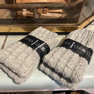Könnte beinhalten: Zwei Paar graue, gestrickte Wollsocken mit schwarzen Etiketten, auf denen "GRASS WEAVERET LANA" steht.