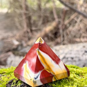 Może przedstawiać: Zestaw trzech ceramicznych kubków z nakrapianym, matowym wykończeniem. Kubki są w odcieniach kremu, jasnoszarym i ciemnoszarym. Każdy kubek ma prosty, minimalistyczny design i zaokrąglony uchwyt.