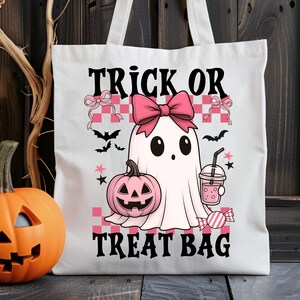Op de afbeelding: Witte canvas draagtas met een Halloween-thema ontwerp. Het ontwerp toont een spook, een roze pompoen en de tekst "Trick or Treat Bag". Inclusief vleermuizen, sterren en een roze strik.