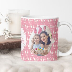 May include: White ceramic mug with a pink background and a white bunny ear pattern. The mug features a photo of a mother and daughter wearing bunny ears and holding a basket of Easter eggs.
