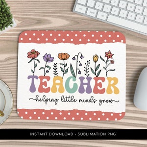 以下が含まれることがあります： ピンクと白のドット柄の背景と白いバナーが付いたマウスパッドの昇華デザイン。バナーには、カラフルな花と「TEACHER helping little minds grow」というテキストが並んでいます。