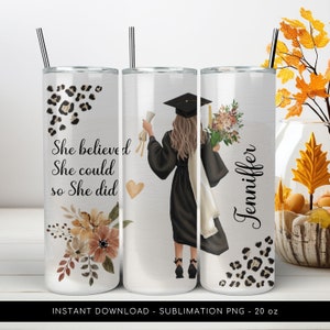 Può includere: Un bicchiere bianco da 20 oz con un design di sublimazione che presenta una laureata che tiene un diploma e dei fiori. Il bicchiere ha un design a stampa leopardata sul fondo e il testo "She believed she could so she did" sul lato sinistro. Il nome "Jenniffer" è scritto sul lato destro del bicchiere.