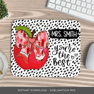 May include: A white and black polka dot mouse pad with a red apple with a pink and red bow. The text "MRS. SMITH you're the best" is written in black cursive.