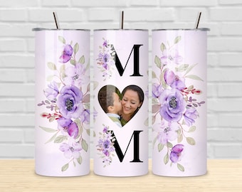 Può includere: Un design di sublimazione per un bicchiere da 20 oz con un motivo floreale viola, una cornice per foto a forma di cuore e le lettere "MOM" in nero. Il design è perfetto per un regalo per la festa della mamma.