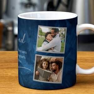 May include: A blue ceramic mug with a white handle. The mug features a collage of two photos of a father and his daughter. The text "My Dad" is written in cursive on the mug. The text "My first hero, my daughter's love." is written in a smaller font below the photos.