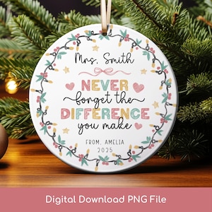 Pode incluir: Enfeite de Natal redondo em cerâmica branca com um design decorativo. O enfeite diz "Mrs. Smith, NEVER forget the DIFFERENCE you make, FROM. AMELIA 2025". É adornado com uma grinalda de luzes, bagas e estrelas.