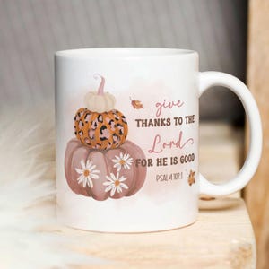 May include: White ceramic mug with a pink, orange, and brown illustration of pumpkins and the text "give thanks to the Lord for he is good Psalm 107:1."