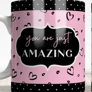 May include: White ceramic mug with a pink background and black polka dots. The mug has a black border with white polka dots and a black and white graphic that says "you are just AMAZING" in a white outline.