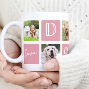 May include: White ceramic mug with a collage of photos and pink squares. The mug displays a photo of a girl with a dog, a golden retriever, and a dog with flowers. The letter "D" is on a pink square, and the word "love" is written in cursive.