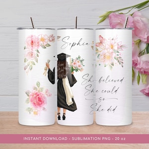 May include: A white sublimation tumbler with a pink floral design and a graduation cap and gown illustration. The text "Sophia" and "She believed she could so she did" is printed on the tumbler.