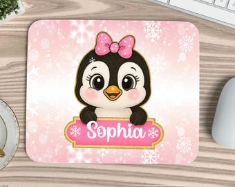 May include: A rectangular mouse pad with a light pink background featuring white snowflakes. A cartoon penguin with a pink polka-dot bow sits above a gold-bordered pink nameplate that displays the name Sophia in white script text.