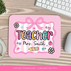 Może przedstawiać: Różowa podkładka pod mysz z białym obramowaniem w kropki i różowo-białym paskiem pośrodku. Słowo "Teacher" jest napisane kolorowymi literami, poniżej "Mrs. Smith". Projekt zawiera kwiaty, serca, ołówek i kokardę.
